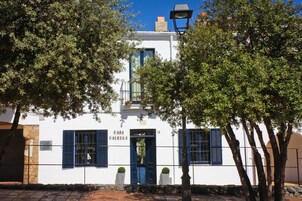 Un edificio blanco con contraventanas azules y un letrero que dice "Casa Echella".