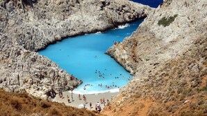 A rocky coastal area with a small beach and clear blue waters. - Esplanade Apartments (Chania)