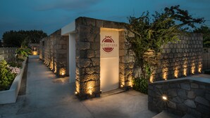 A stone pathway leading to a building with a sign reading "Helagrana Apartments." - Melagrana (Milos)