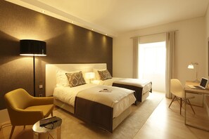 Een hotelkamer met twee bedden, een bureau, een stoel en een lamp.