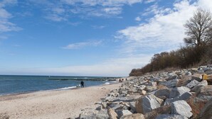 A rocky beach with a clear sky and calm sea.