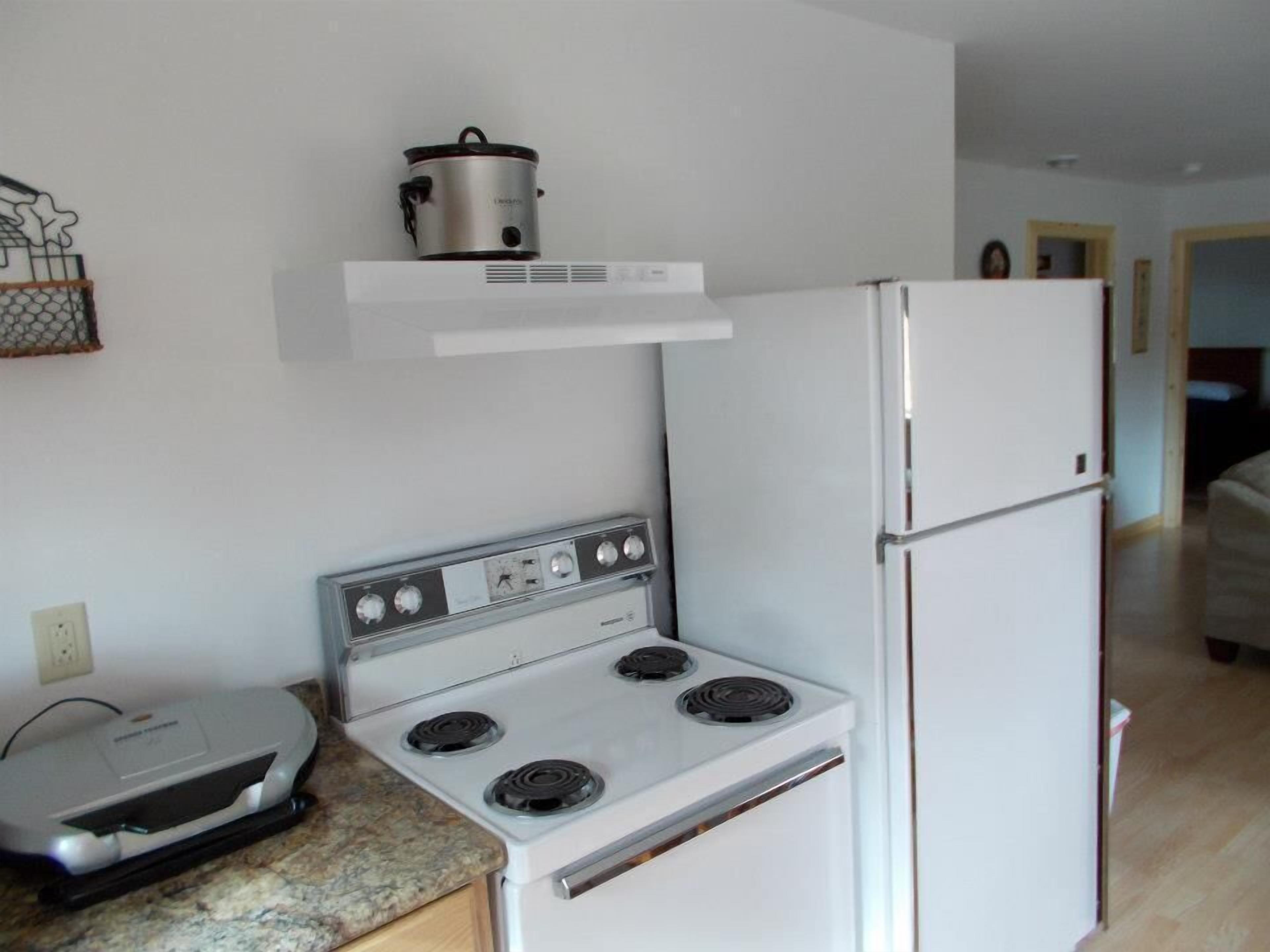 Cocina compacta con estufa, horno y refrigerador.