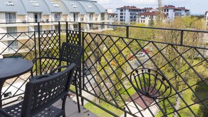 A balcony with a view of residential buildings and a spiral staircase.