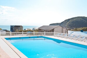 Een seizoensgebonden buitenzwembad, een zwembad op het dak en ligstoelen