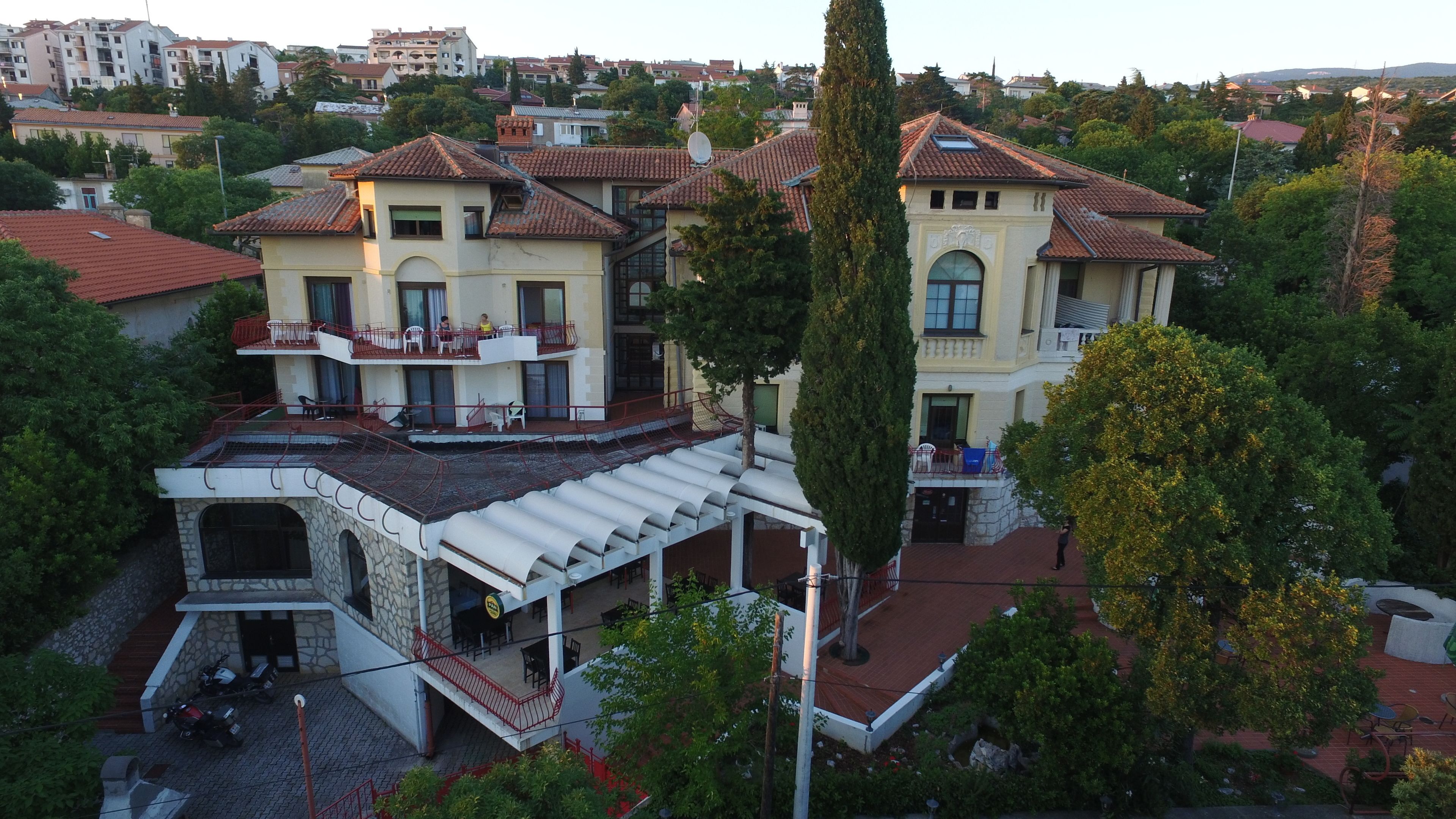 A large, multi-story building with a central courtyard, balconies, and a mix of architectural styles.