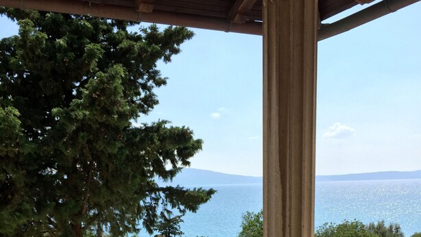 A balcony with a view of the sea, a stone balustrade, and a large tree. - Hotel Ruža (Novi Vinodolski)