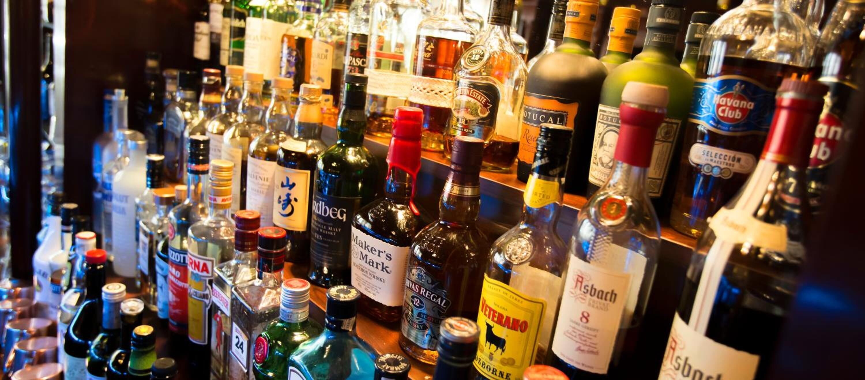 Een bar met diverse flessen drank.