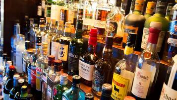 Een bar met diverse flessen drank.