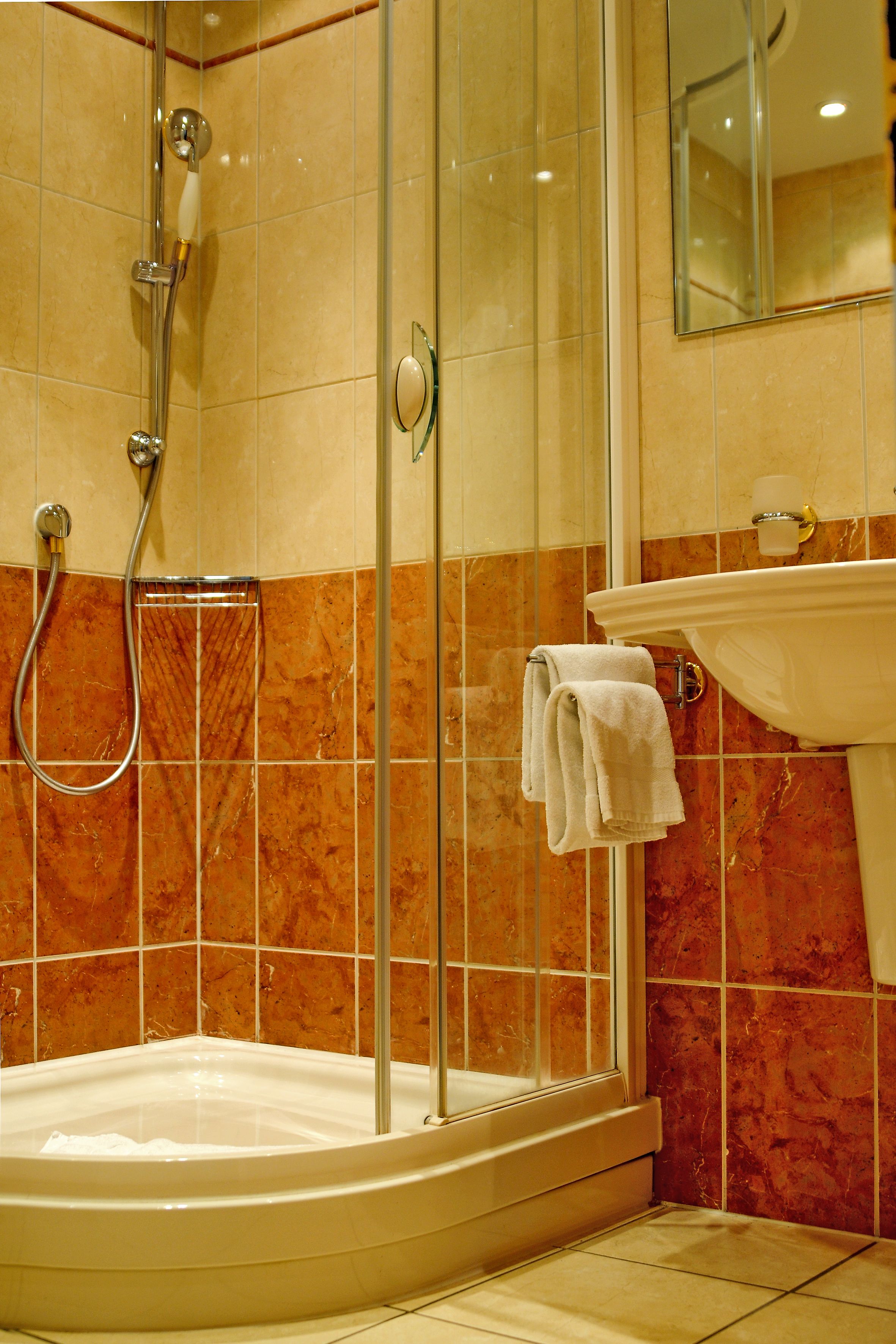 Ein Badezimmer mit Duschkabine, Badewanne und Waschbecken mit Spiegel darüber.