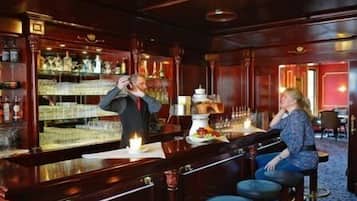 Eine Bar mit einem Barkeeper und einem Gast, der sitzt.