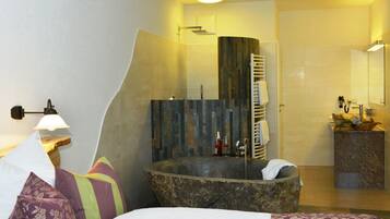 A modern bathroom with a freestanding bathtub, a shower, and a vanity with a mirror.