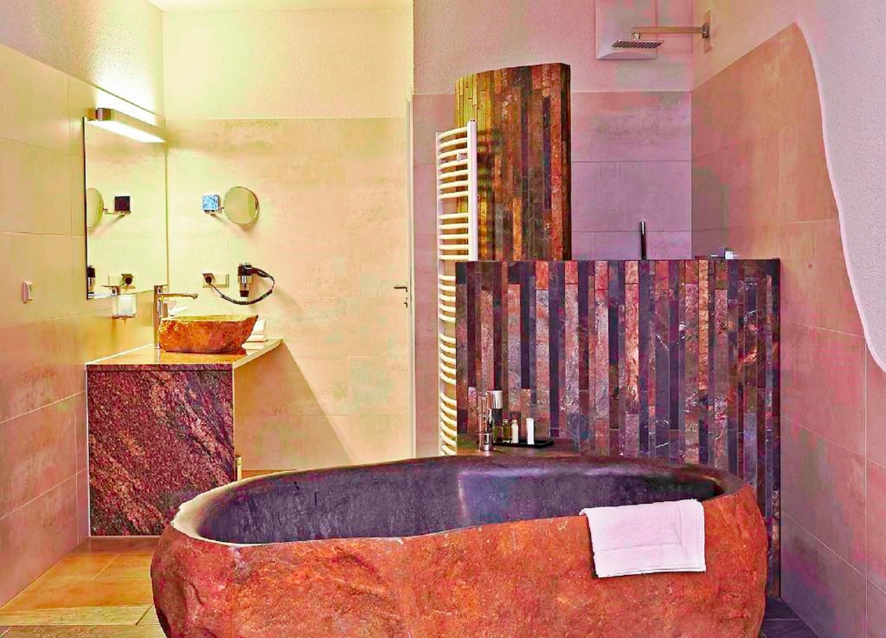 Ein modernes Badezimmer mit einer freistehenden Badewanne, einem мраморном Waschbecken und einem großen Spiegel.