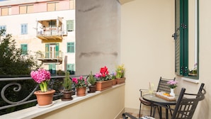A balcony with potted plants, a table with chairs, and a magazine. - Priska Heritage Rooms (Split)