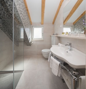A modern bathroom with a glass shower enclosure, a white sink, and a toilet. - Priska Heritage Rooms (Split)