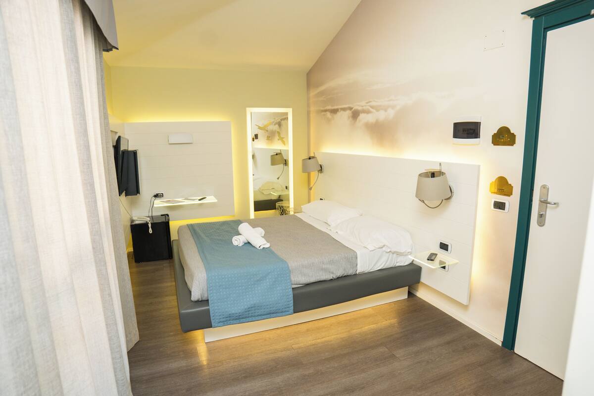 Ein modernes Schlafzimmer mit einem Bett, Nachttisch und einem Spiegel.