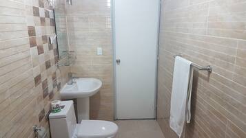 Un baño pequeño con inodoro, lavabo y perchero para toallas.