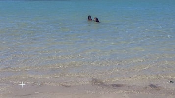 Am Strand, weißer Sandstrand, Sonnenschirme, Strandtücher