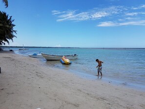 En la playa, playa de arena blanca, sombrillas y toallas de playa 