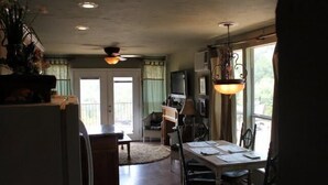 A kitchen with a dining table, chairs, a refrigerator, and a television. - Turner Falls (Davis)