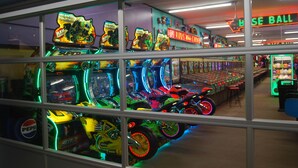 A brightly lit arcade with neon signs and various gaming machines. - Midtown Cottages (Myrtle Beach)