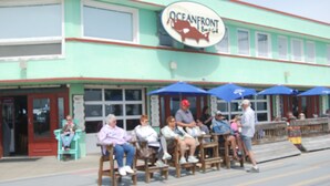 A building with a sign reading "Oceanfront Bar & Grill". - Midtown Cottages (Myrtle Beach)