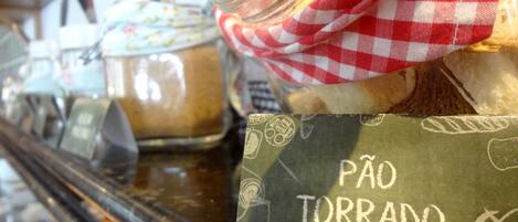 Mostrador de panadería con pan y pasteles, un mantel a cuadros y un letrero que dice
