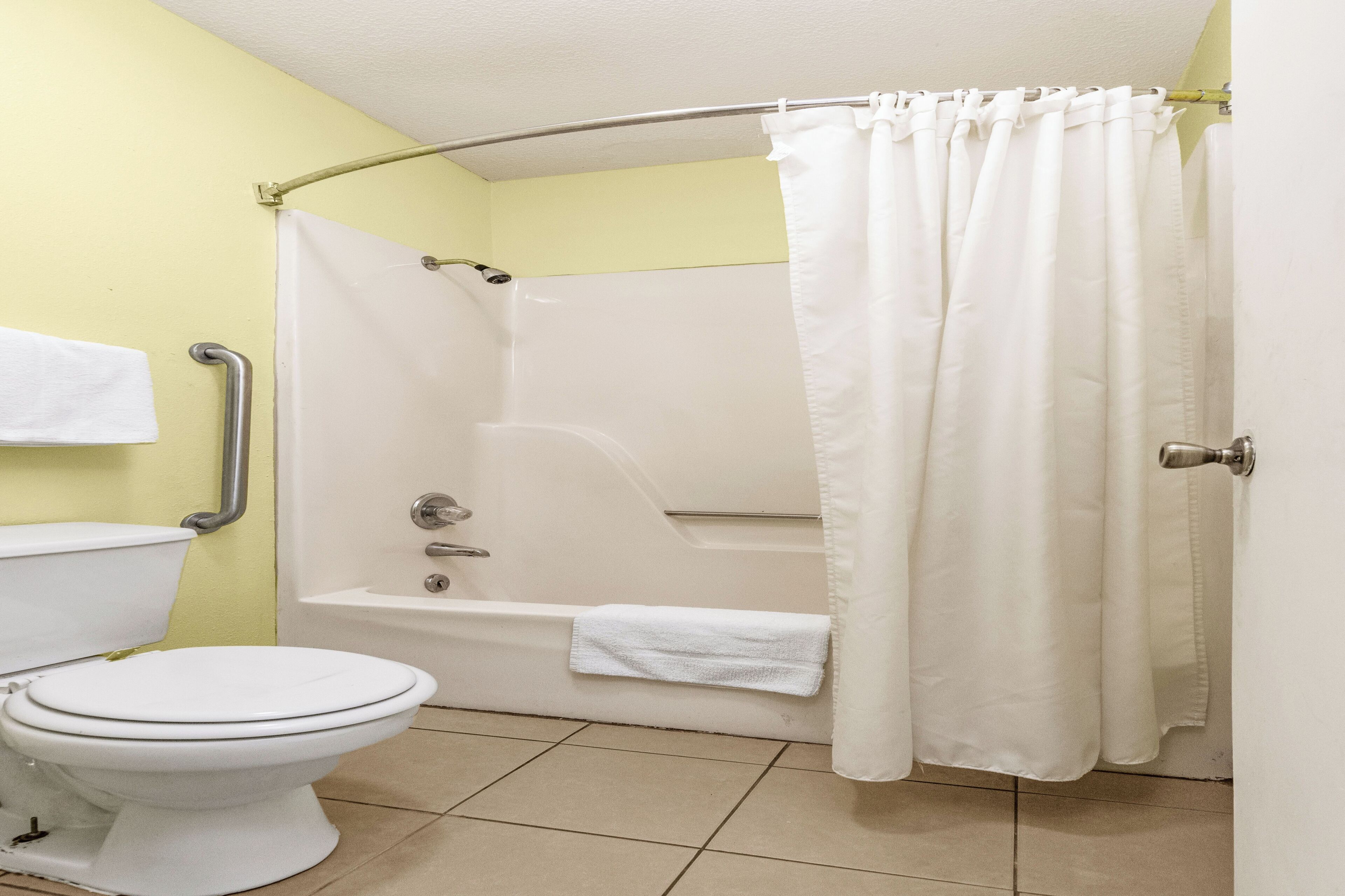 Un baño con inodoro, bañera y cortina de ducha.