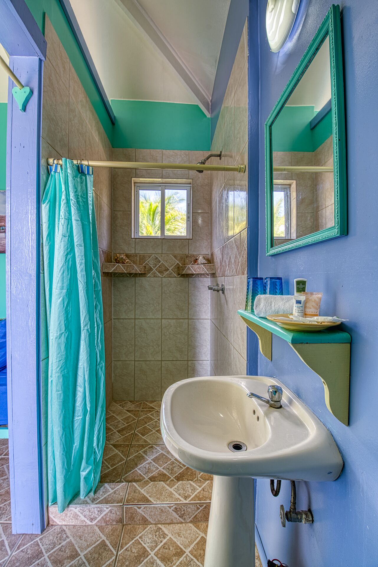 Un baño con ducha, lavamanos y espejo.