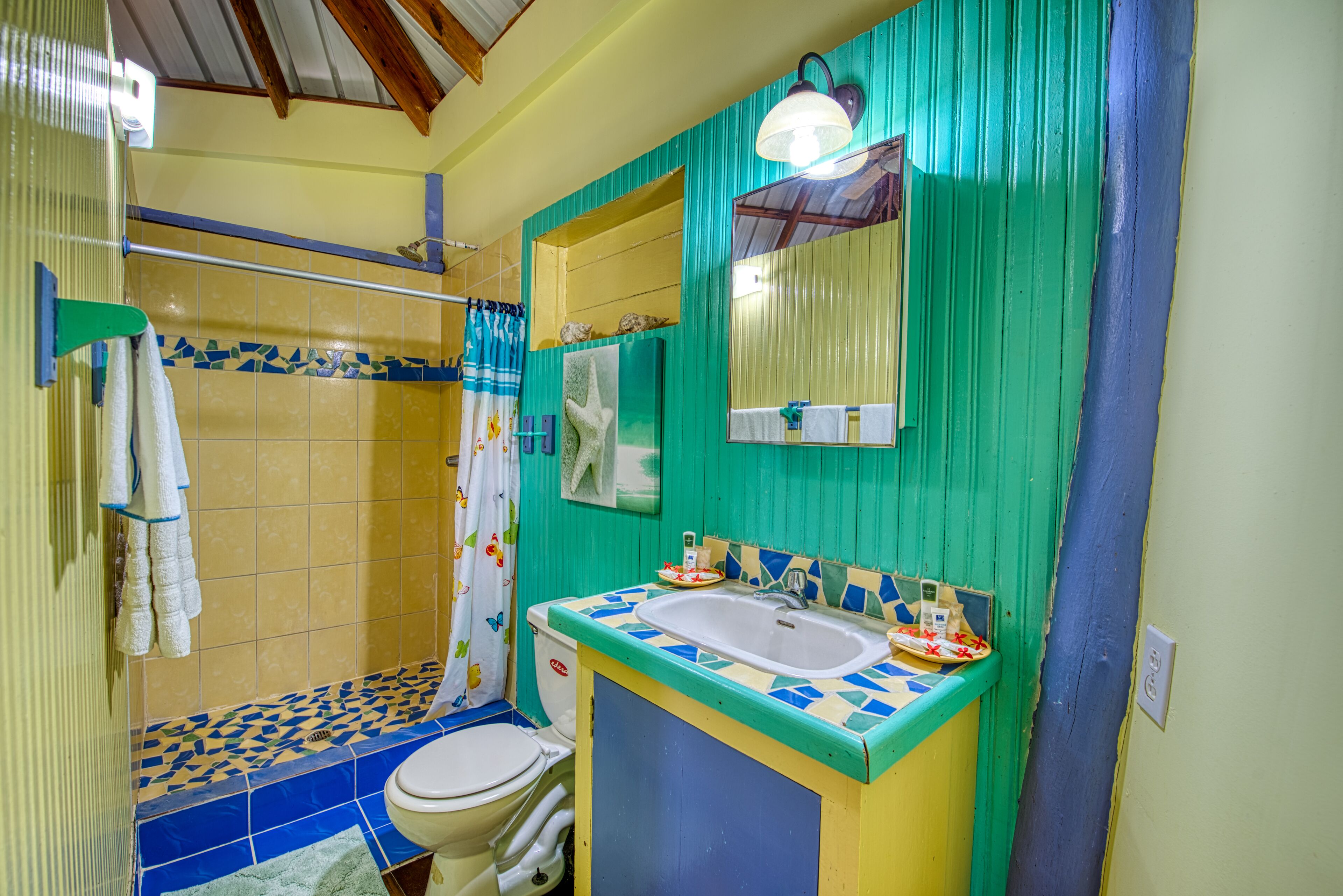 A bathroom with a toilet, sink, and shower area.