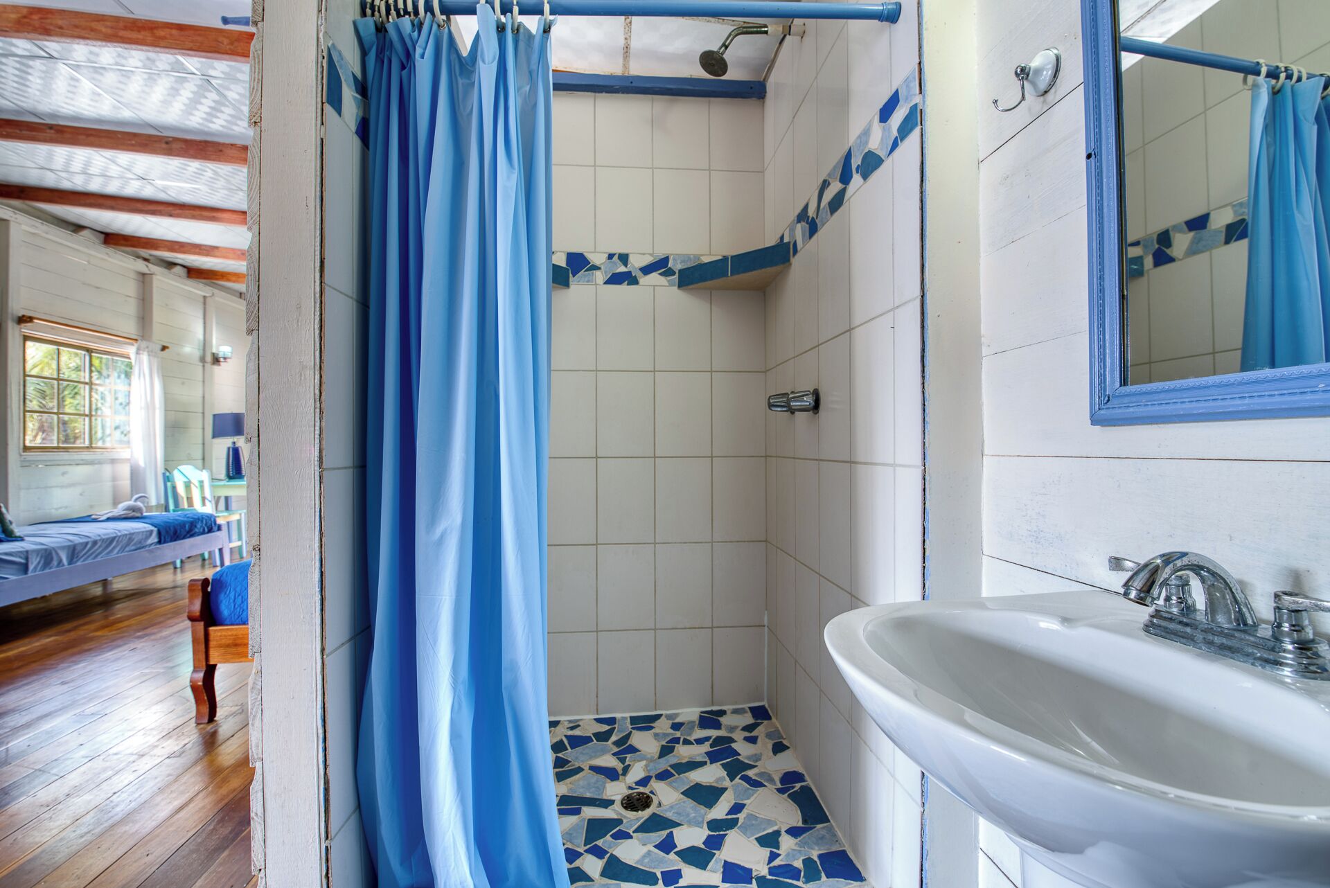 Une salle de bain avec une douche, un lavabo et un miroir.