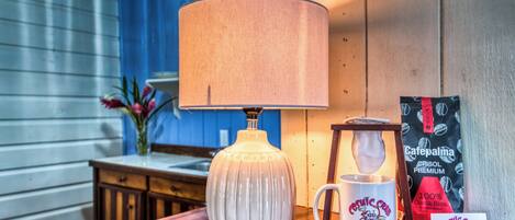 A wooden table with a white lamp, a mug, and a bag of Cafépalma premium coffee.