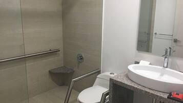 A bathroom with a shower, toilet, and sink.
