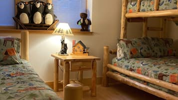 Cozy children's room with a bunk bed, wooden table, and plush toy bear.