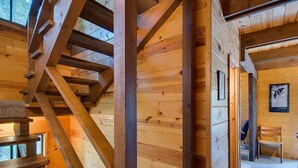 A wooden interior with a spiral staircase, wooden walls, and a framed picture on the wall.