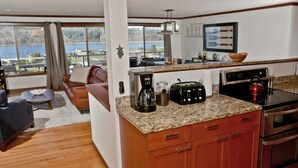 Una cocina moderna con encimeras de granito, electrodomésticos de acero inoxidable y vistas a un lago.