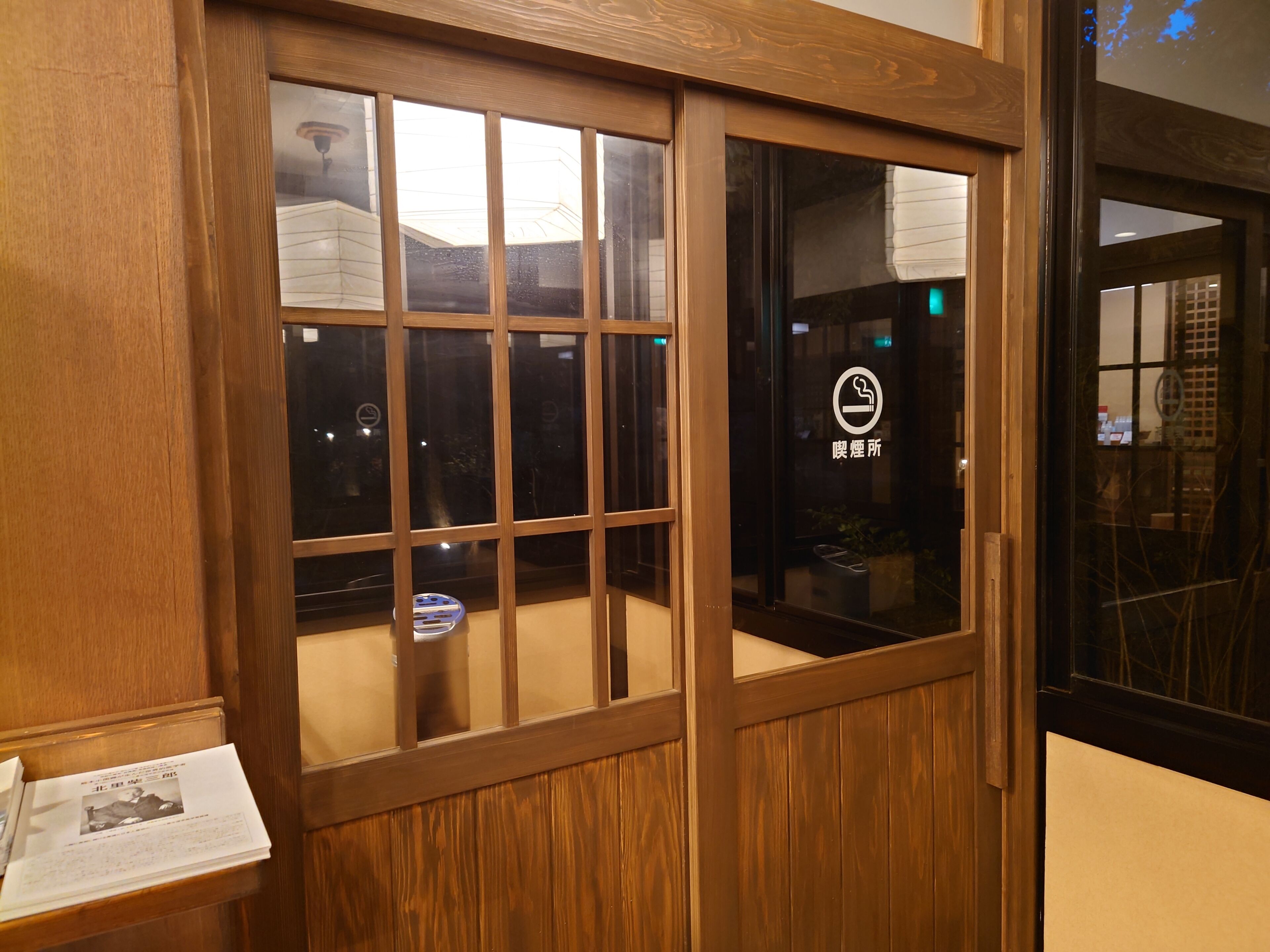 A wooden-framed window with a view of a building exterior.