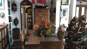 Zona pranzo con tavolo e sedie in legno, un centrotavola decorativo e una ventola a soffitto.