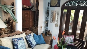 Un accogliente soggiorno con un divano di legno, un tavolino da caffè con libri e una pianta decorativa.