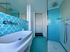 A modern bathroom with a large bathtub, a shower area, and a tiled floor.