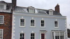 A two-story building with a red door and multiple windows.