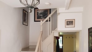 A staircase with white railings and a patterned floor leading to a room with a wooden bench.