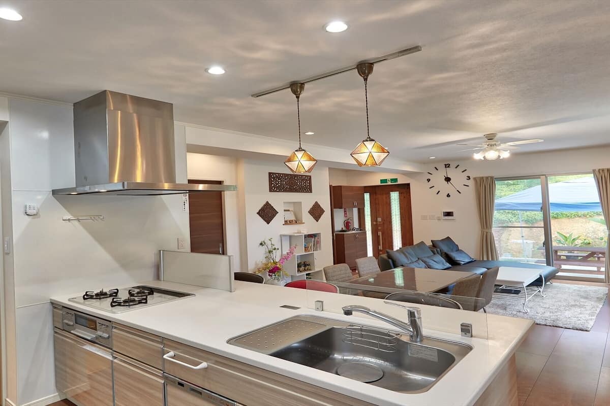 A modern kitchen with a central island, stainless steel appliances, and pendant lighting.