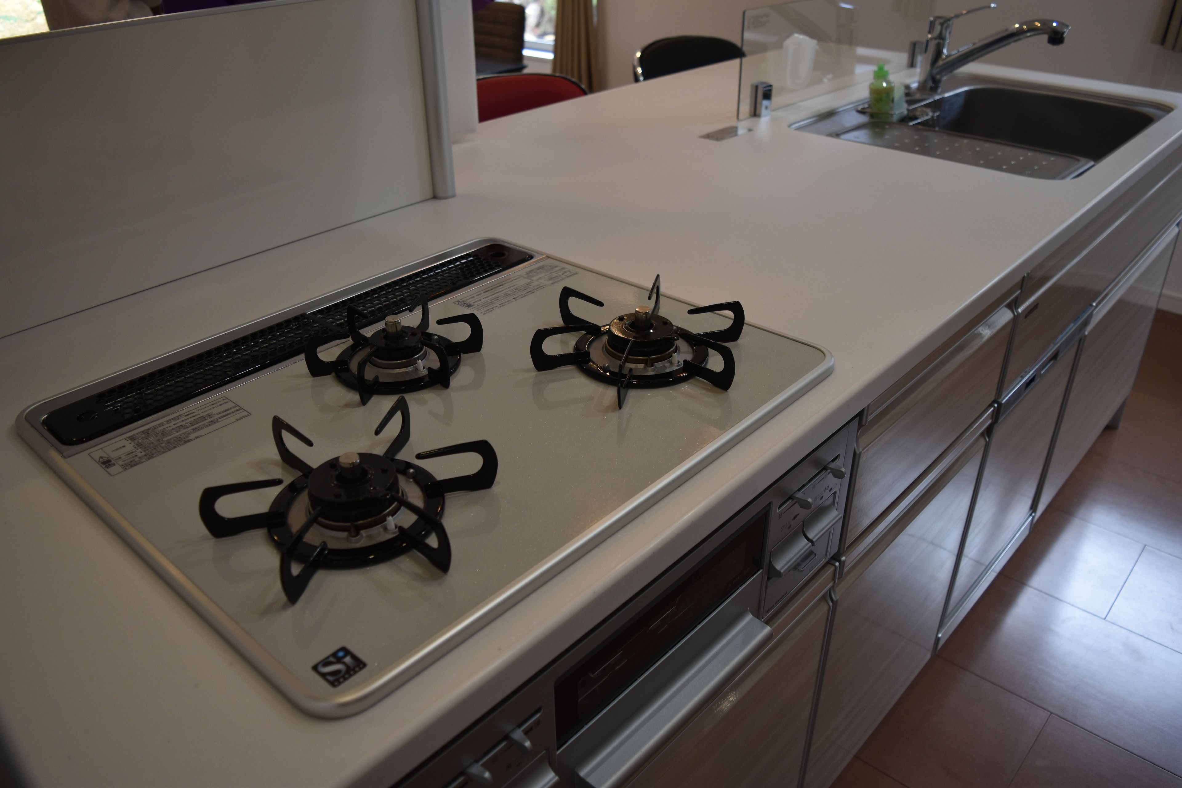 Una cocina con estufa blanca, electrodomésticos de acero inoxidable y un lavamanos.