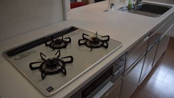 Una cocina con estufa blanca, electrodomésticos de acero inoxidable y un lavamanos.