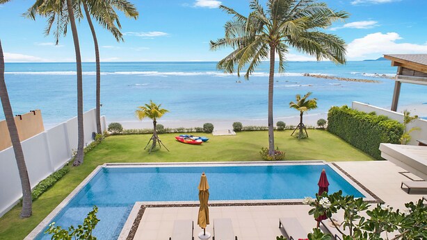 Une piscine dotée de chaises longues et offrant une vue sur l’océan.