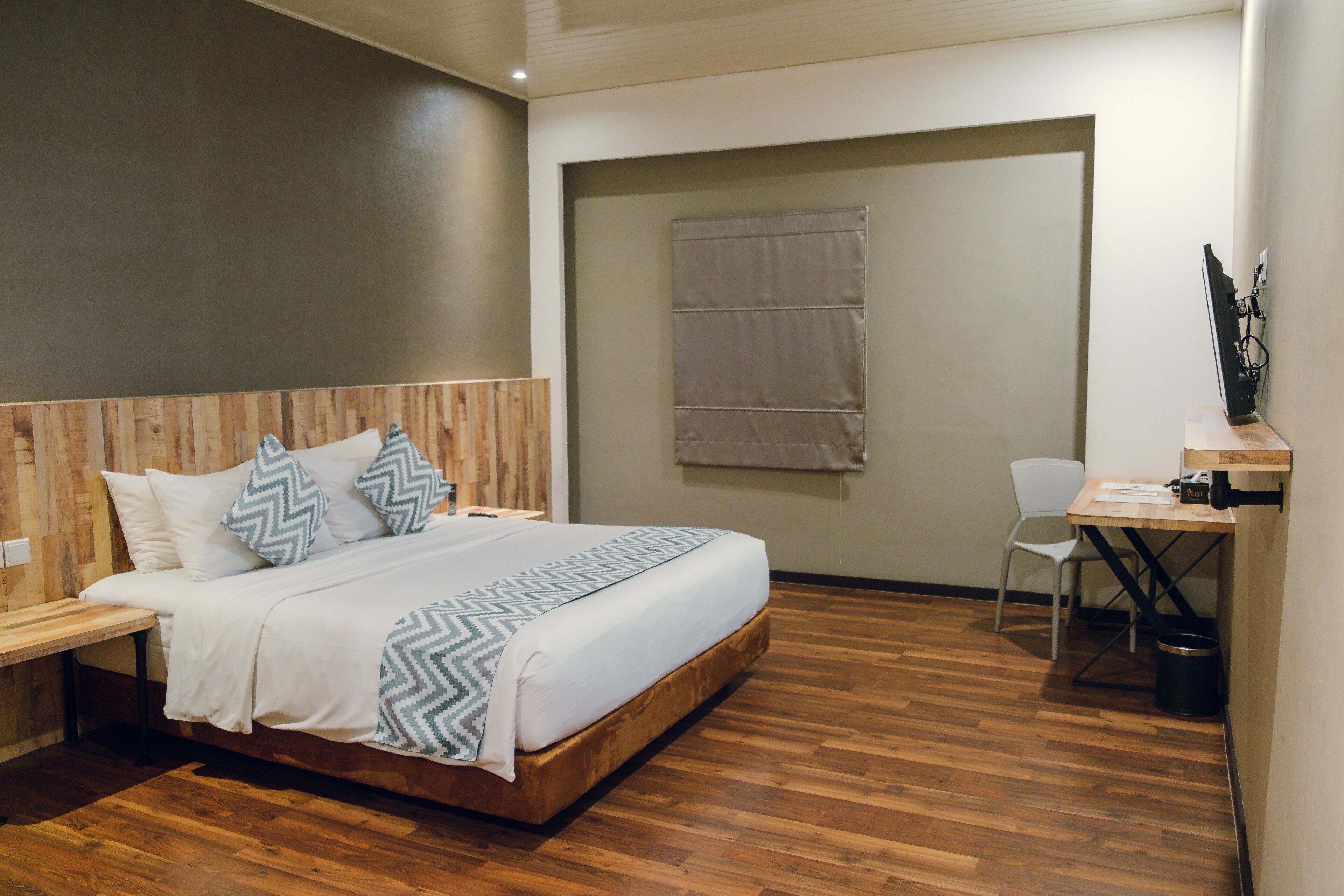 Un dormitorio con una cama de madera, un escritorio y una silla.