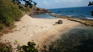 A coastal beach with clear waters, a sandy path, and rocky outcrops. - My cabin-Star Trail (POINTE NOIRE)