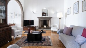 Una sala de estar con chimenea, televisor, sofá y mesa de centro.