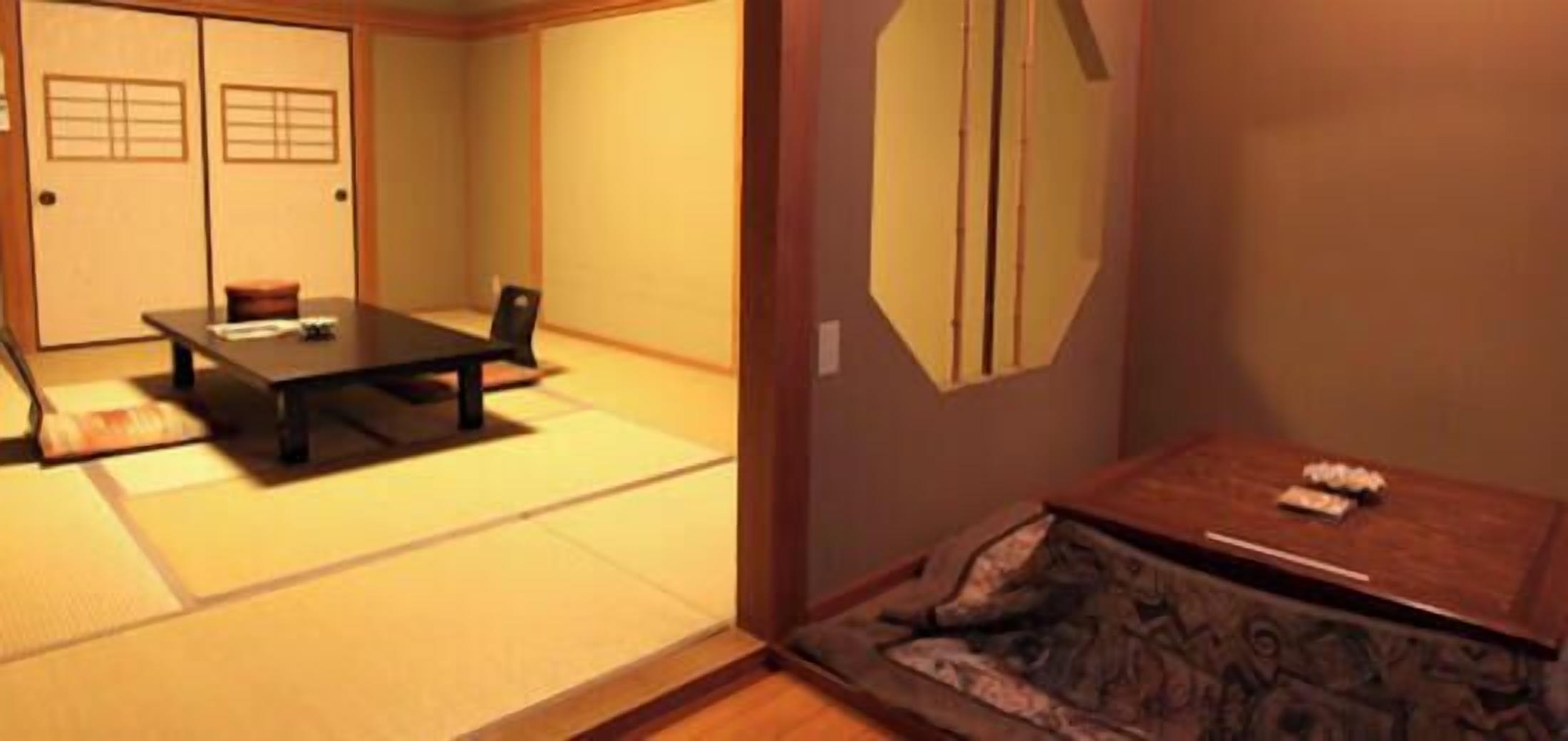 Una habitación japonesa tradicional con suelo de tatami, una mesa baja y un futón.
