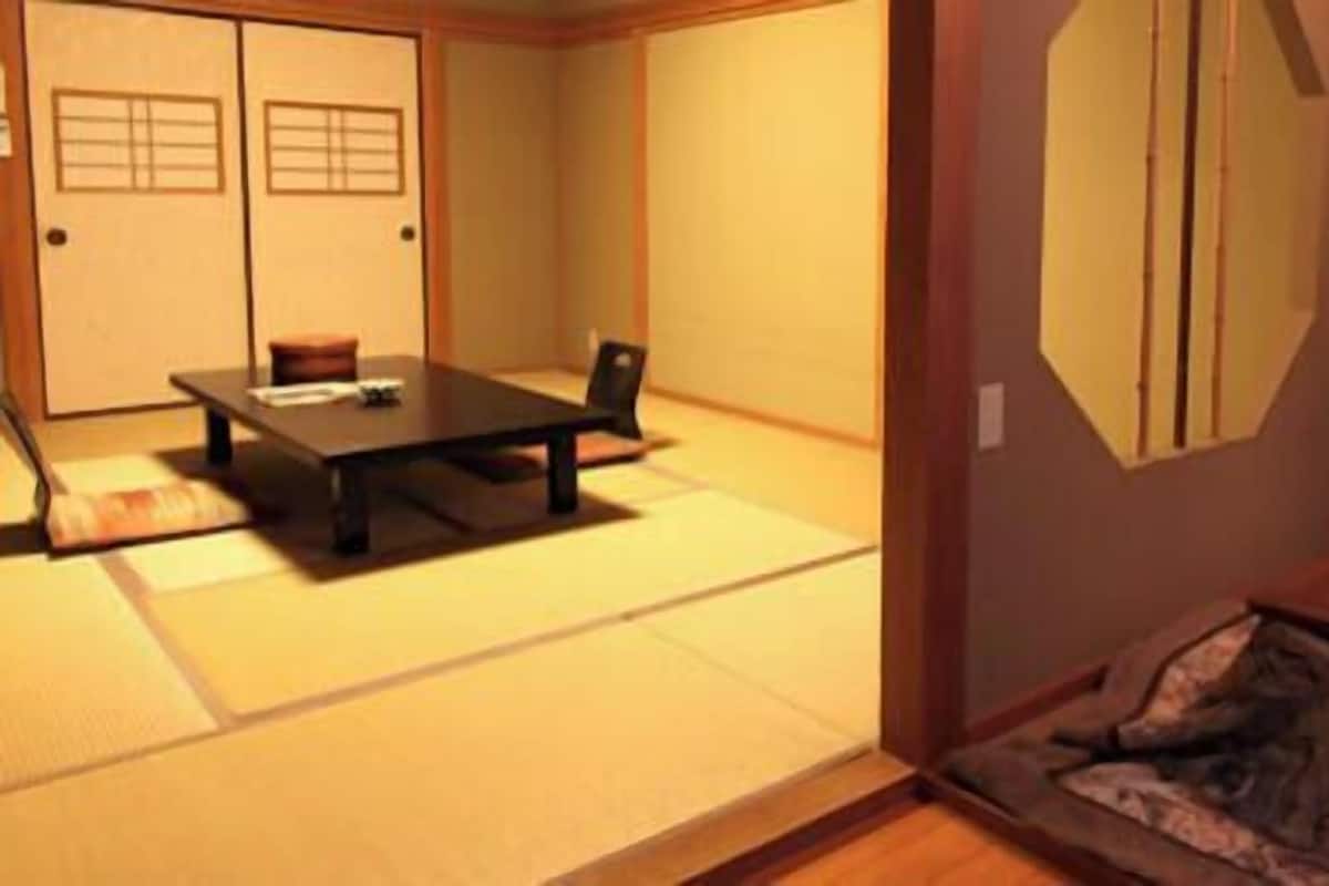 A traditional Japanese room with tatami flooring, a low table, and a futon bed.
